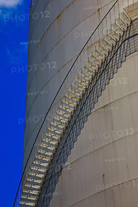 Metal staircase on a large industrial gas tank under a clear blue sky, elevated tank, chemical, company, Grenzach- Wyhlen, Baden-Württemberg, Germany