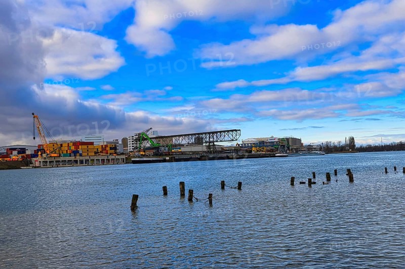 Industrial harbour with containers and cranes under a cloudy blue sky on a river, Rhine, Birsfelden harbour, Canton Baselland, Switzerland