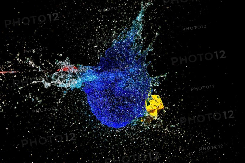 A blue water balloon explosion with yellow accents, triggered by an arrow, in a dynamic scene, high-speed shot, water balloon, arrow