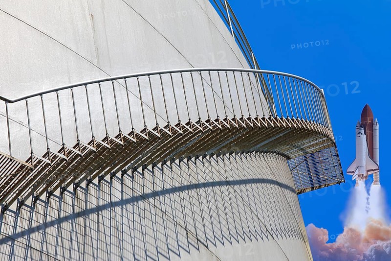 A rocket launches next to a large tank with a metal staircase in the foreground, elevated tank, chemicals, company, Grenzach- Wyhlen, Baden-Württemberg, Germany