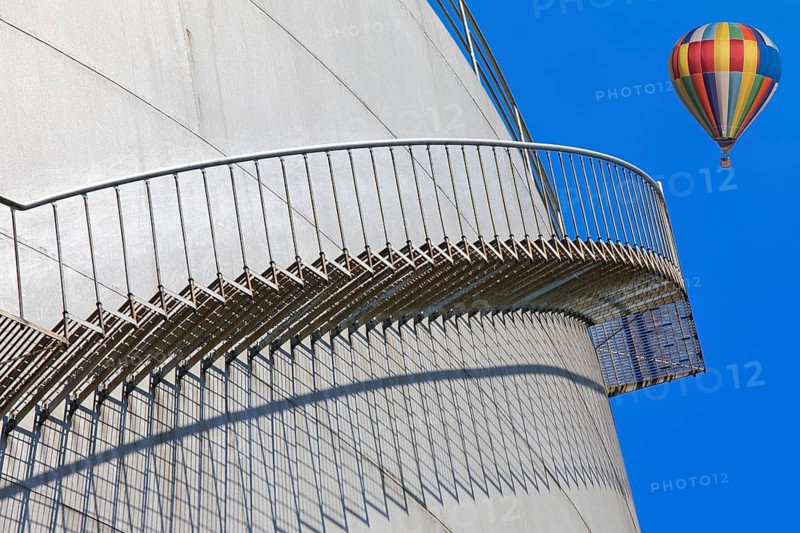 Metal staircase on a tank with a colourful hot air balloon in the sky, elevated tank, chemical, company, Grenzach- Wyhlen, Baden-Württemberg, Germany