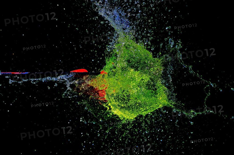 A green water balloon is pierced by an arrow and explodes in a dark, dynamic scene, high-speed shot, water balloon, arrow