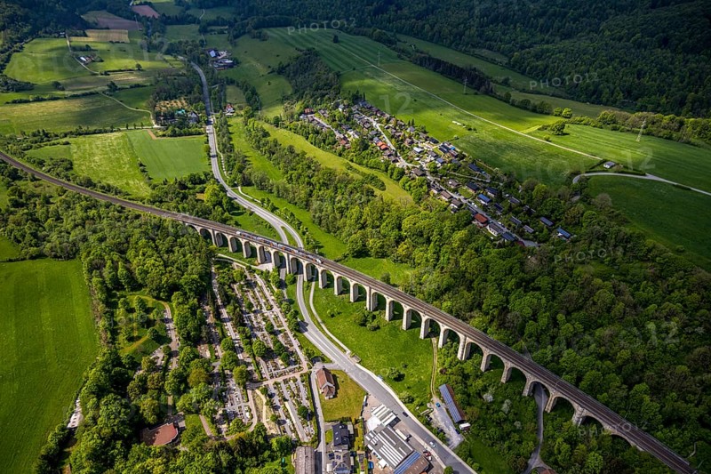 Aerial view, Altenbekener Viaduct, Adenauerstraße, railway viaduct Bridge structure, also called Bekeviaduct or Great Viaduct, suburban railway, Altenbeken cemetery and cross chapel on the Alter Kirchweg road, residential area Am Stapelsberg, meadows and fields, Altenbeken, East Westphalia, North Rhine-Westphalia, Germany, railway viaduct, bridge construction, Beke Viaduct, Great Viaduct, Altenbeken Cemetery, Cross Chapel, Alter Kirchweg road, meadows, fields, infrastructure, traffic, landscape, rural, architecture, train, railway, cemetery, chapel, residential area, agricultural landscape, hill, nature, building, railway, urban, village, town, green, field work, rural scene