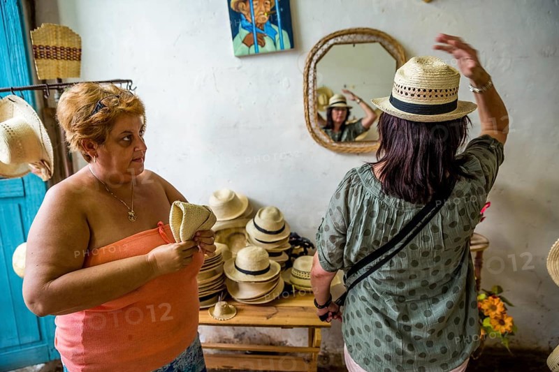 Cuban hat saleswoman with a tourist in a shop in the old town of Trinidad, Trinidad, Cuba, Sancti Spíritus, Cuba, Sancti Spíritus