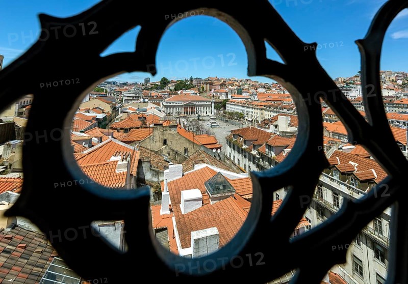 View through wrought iron grating from Portugal's most famous lift Elevador do Município or Elevador da Biblioteca and Elevador de S. Julião to the old town of Portugal with the red roofs, Lisbon, District of Lisbon, Portugal