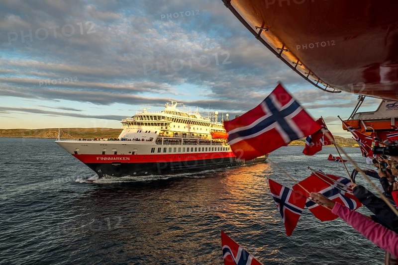 Tourists at the ship's railing, ship MS Finnmarken, Norwegian flags, Mehamn, Finnmark, Norway, Scandinavia, Europe, adventure trip, welcoming the passengers, tourism, Hurtigruten, Hurtigruten trip, cruise, cruise ship, liner, NOR, passenger ship, shipping company Hurtigruten AS, travel, destination, shipping, sea trip, sightseeing, tourism, Norwegian, Norwegian flag, Scandinavian, touristic