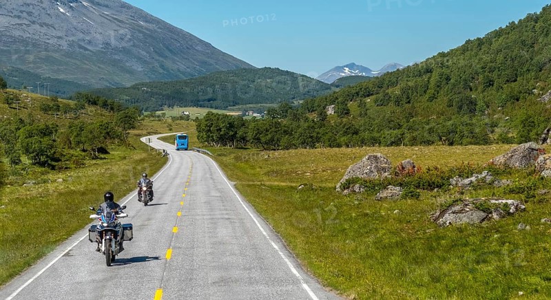 Motorcyclist and coach on the European route 63, Geiranger, Møre og Romsdal, Norway, Scandinavia, Europe, adventure trip, mountains, tourism, Hurtigruten, Hurtigruten trip, hilly landscape, cruise, Møre og Romsdal, NOR, travel, destination, sea trip, sightseeing, tourism, forest area, meadows and fields, Norwegian, Scandinavian, touristic