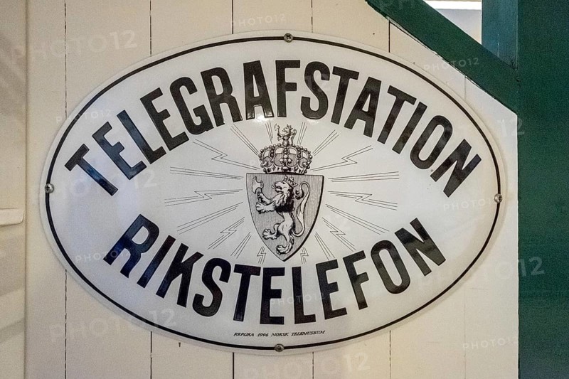 Travel by Flam Railway, Iron Railway, White sign with black lettering, TELEGRAFSTATION RINKSTELEFON, Flåm, Sogn og Fjordane, Norway, Scandinavia, Europe, Flåm, NOR, travel, tourism, destination, sightseeing, sea voyage, Hurtigruten, Hurtigruten voyage, tourism, Norwegian, Scandinavian, tourist, cruise, adventure trip, labelling, information