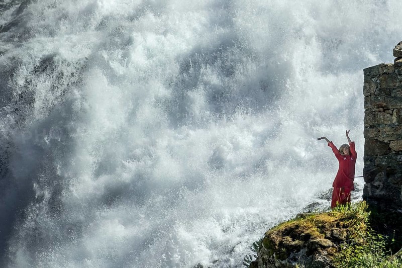 Red dressed woman is a Huldra, fairy, legendary figure, Kjosfossen waterfall, waterfall near Fureberget, dancer in red dress, rock walls, Flåm, Sogn og Fjordane, Norway, Scandinavia, Europe, Flåm, NOR, travel, tourism, destination, sightseeing, sea voyage, Hurtigruten, Hurtigruten trip, tourism, Norwegian, Scandinavian, touristic, cruise, adventure trip, waterfall, stone wall, mountains, Flamsbahn, Flamsbana, train journey, tour, travel with the Flam Railway, Flam Railway