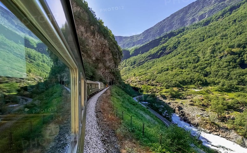 Journey by Flam Railway, iron railway journey, view from Flåmsbana, Ryavegen, entrance to tunnel, mountains, forests, meadows, fjord, blue sky, Flåm, Sogn og Fjordane, Norway, Scandinavia, Europe, Flåm, NOR, travel, tourism, destination, sightseeing, sea voyage, Hurtigruten, Hurtigruten trip, tourism, Norwegian, Scandinavian, tourist, cruise, adventure trip, trees, tree, forest, forestry, forestry, hill, gravel, wooden house, valley, road, tunnel, power lines