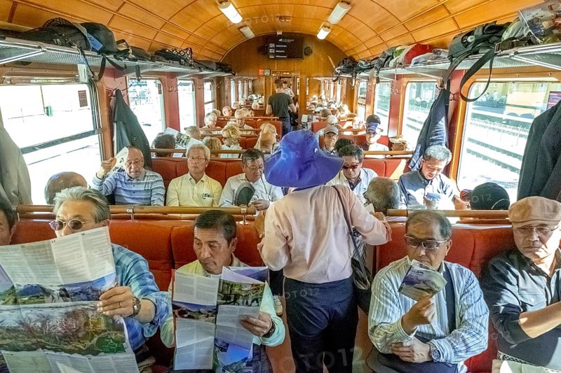 Travel by Flam Railway, iron railway journey, tourists in Flåmsbana, Flåm, Sogn og Fjordane, Norway, Scandinavia, Europe, Flåm, NOR, travel, tourism, destination, sightseeing, sea voyage, Hurtigruten, Hurtigruten trip, tourism, Norwegian, Scandinavian, tourist, cruise, adventure trip, reading, sitting, walking