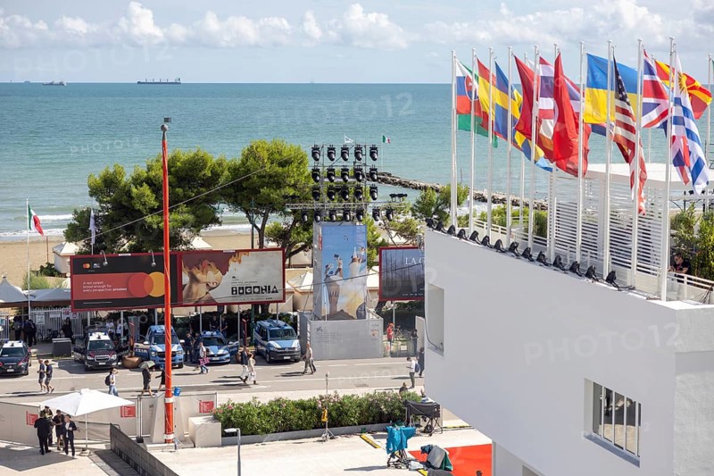 Venice, Italy - 2 September 2025: Spectators and guests walk past a film poster in front of the Palazzo del Cinema during the 82nd Venice International Film Festival