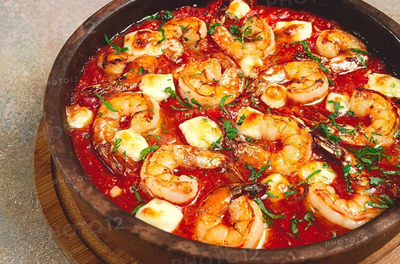 Saganaki with shrimp, in a clay pan, Greek dish, shrimp in tomato sauce, feta cheese, homemade, no people