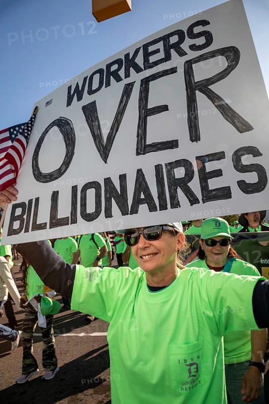 Detroit, Michigan USA - 1 September 2025 - A member of the International Brotherhood of Electrical Workers carries a 'Woirkers Over Billionaires' sign in Detroit's Labor Day parade