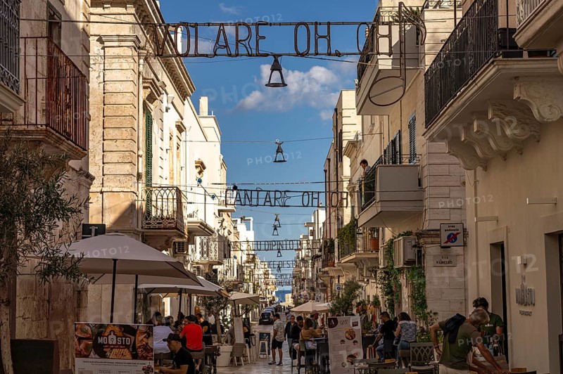 The lyrics of the song VOLARE Nel blu dipinto di blu as illumination over the pedestrian zone Via Roma, Polignano a Mare, Apulia, Italy