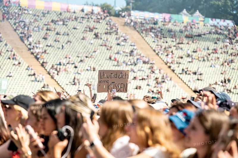 Festival visitors hold up a sign I'd like to kiss you at 01099 at the Superbloom Festival, day 2 in the Olympic Park, Munich, 31-08-2025