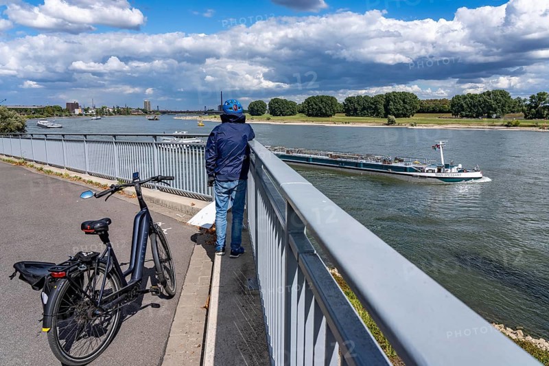 Cargo ships on the Rhine near Duisburg, in the background the Friedrich-Ebert-Bridge between Duisburg-Homberg and Rheinhausen, spectator, North Rhine-Westphalia, Germany