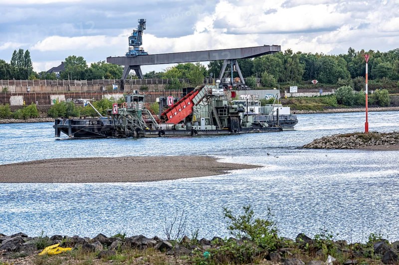 Bucket chain dredger at work on the Rhine near Duisburg, between the Neuenkamper Rhine Bridge and the Friedrich-Ebert Bridge in Ruhrpott, dredging the navigation channel, North Rhine-Westphalia, Germany
