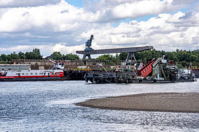 Bucket chain dredger at work on the Rhine near Duisburg, between the Neuenkamper Rhine Bridge and the Friedrich-Ebert Bridge in Ruhrpott, dredging the navigation channel, North Rhine-Westphalia, Germany