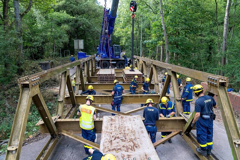 Construction of a temporary bridge over a slipped road crossing a stream, by the bridge construction section of the THW, 18 metre long steel bridge of the Krupp-D type, is assembled in around 8 hours, large-scale exercise FÜLEX25 lasting several days, of the THW North Rhine-Westphalia regional association, over 3500 volunteers from the 127 North Rhine-Westphalia local associations practise on 4 weekends, many different deployment scenarios