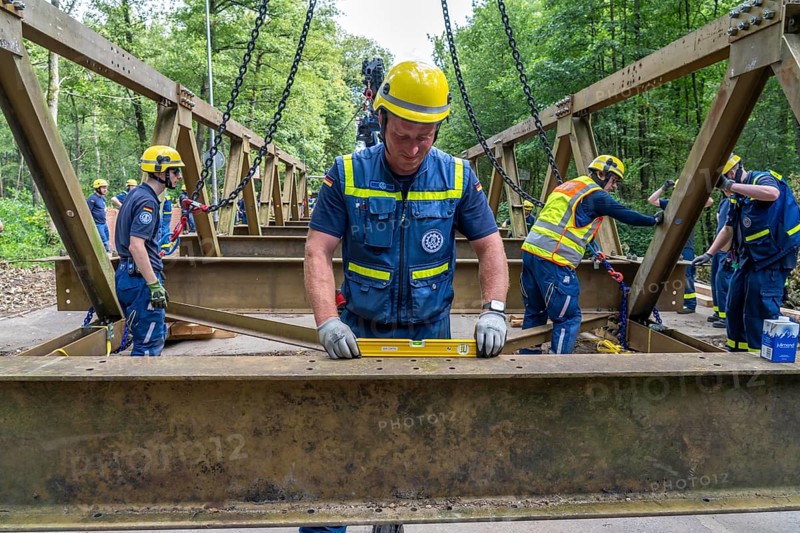 Construction of a temporary bridge over a slipped road crossing a stream, by the bridge construction section of the THW, 18 metre long steel bridge of the Krupp-D type, is assembled in around 8 hours, large-scale exercise FÜLEX25 lasting several days, of the THW North Rhine-Westphalia regional association, over 3500 volunteers from the 127 North Rhine-Westphalia local associations practise on 4 weekends, many different deployment scenarios