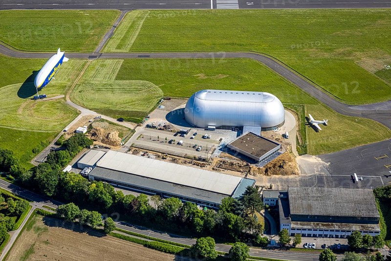 Aerial view, Airport Essen/Mülheim, Goodyear airship Zeppelin, construction site next to the WDL airship hangar, parked aeroplanes, Holthausen - south-east, Mülheim an der Ruhr, Ruhr area, North Rhine-Westphalia, Germany, construction work, construction area, construction site, building plots, construction project, construction site, DE, Europe, aerial view, aerial photography, aerial photography, overview, bird's-eye view, overview