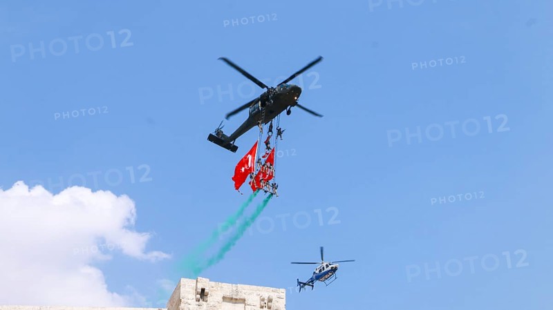Türkiye special operations police hang from a helicopter with ropes, carrying weapons and unfurling a large Turkish flag while saluting citizens during an aerobatic air show at Teknofest technology festival. Gaziantep, Türkiye. September 24, 2020, Gaziantep, Gaziantep, Türkiye