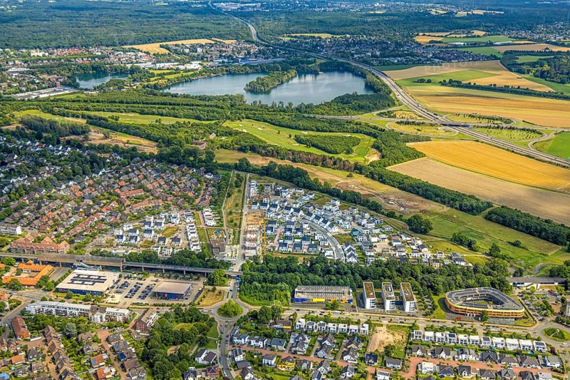 Aerial view, Duisburg-Süd, residential area Angerbogen, Am Alten Angerbach, semi-circular new housing estate, commercial area Xella International GmbH and Edeka E-Center Angerbogen, roofed railway station Angerbogen, behind the Rahmer See, Huckingen, Duisburg, Ruhr area, North Rhine-Westphalia, Germany, Ruh