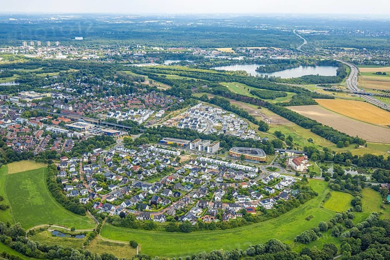 Aerial view, Duisburg-Süd, residential area Angerbogen, Am Alten Angerbach, semi-circular new housing estate, commercial area Xella International GmbH and Edeka E-Center Angerbogen, roofed railway station Angerbogen, behind the Rahmer See, Huckingen, Duisburg, Ruhr area, North Rhine-Westphalia, Germany