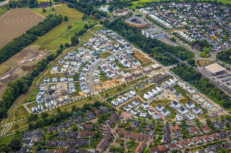 Aerial view, Duisburg-Süd, residential area Angerbogen, Am Alten Angerbach, semi-circular new housing estate, commercial area Xella International GmbH and Edeka E-Center Angerbogen, roofed railway station Angerbogen, behind the Rahmer See, Huckingen, Duisburg, Ruhr area, North Rhine-Westphalia, Germany