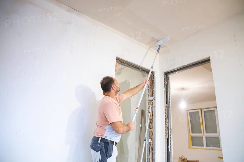 Wallpapering work: Priming the ceiling for the application of wallpaper