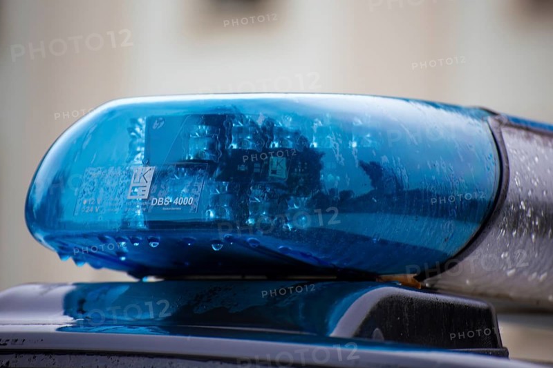 Symbolic image of a police operation: close-up of a flashing blue light on a police car