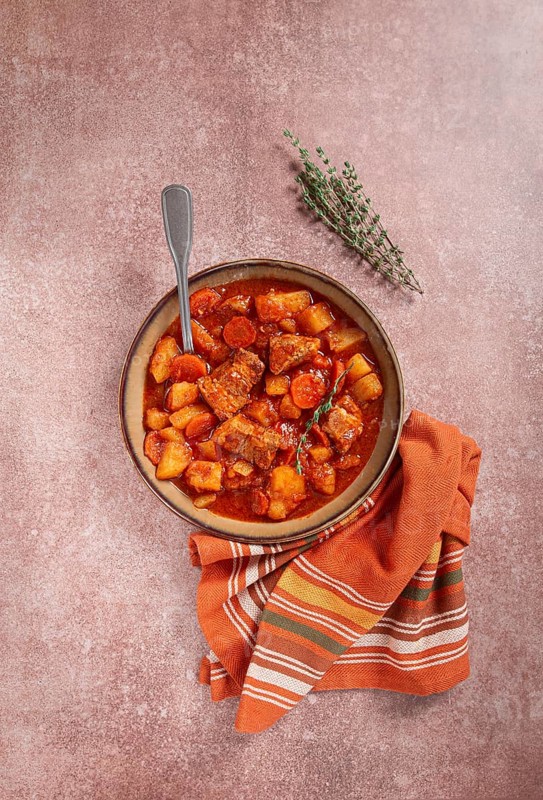 Meat goulash with potatoes and carrots, sweet peppers, in a saucepan, top view, traditional Hungarian soup, homemade, no people