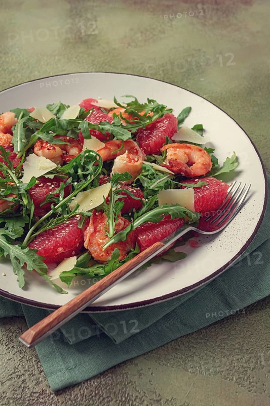 Fresh shrimp salad with arugula, grapefruit, and parmesan served in a bowl