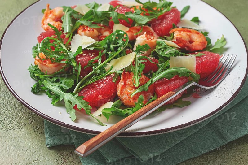 Fresh shrimp salad with arugula, grapefruit, and parmesan served in a bowl