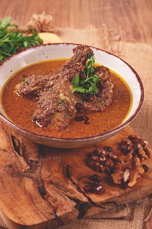Fesenjan, an Iranian dish, stewed chicken, in a nut-pomegranate sauce, in a bowl, homemade, no people