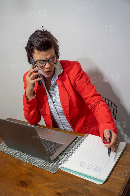 Focused businesswoman writing down important details from a call