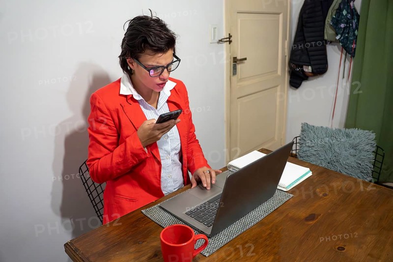 Modern professional having a phone meeting while working on a laptop