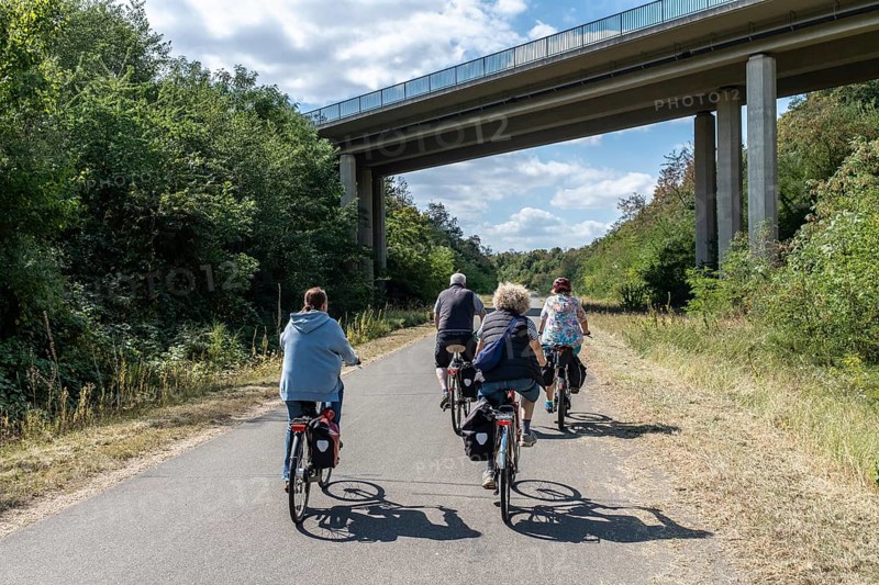 Group of cyclists under bridge at Hambach open-cast mine, Rhineland-Palatinate, Germany