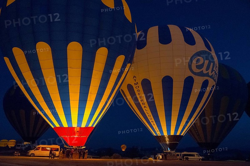Illuminated hot air balloons glow in the dark, surrounded by a tranquil landscape, Göreme National Park, Göreme Tarihî Millî Parki, Nevsehir Province, Nevsehir, Cappadocia, Cappadocia, Cappadocia, Cappadocia, Central Anatolia, Turkey