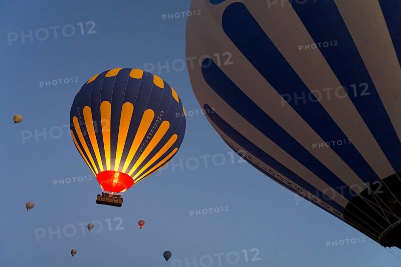 Hot air balloons in blue and yellow stand out against the morning sky, Göreme National Park, Göreme Tarihî Millî Parki, Nevsehir Province, Nevsehir, Cappadocia, Cappadocia, Cappadocia, Cappadocia, Central Anatolia, Turkey