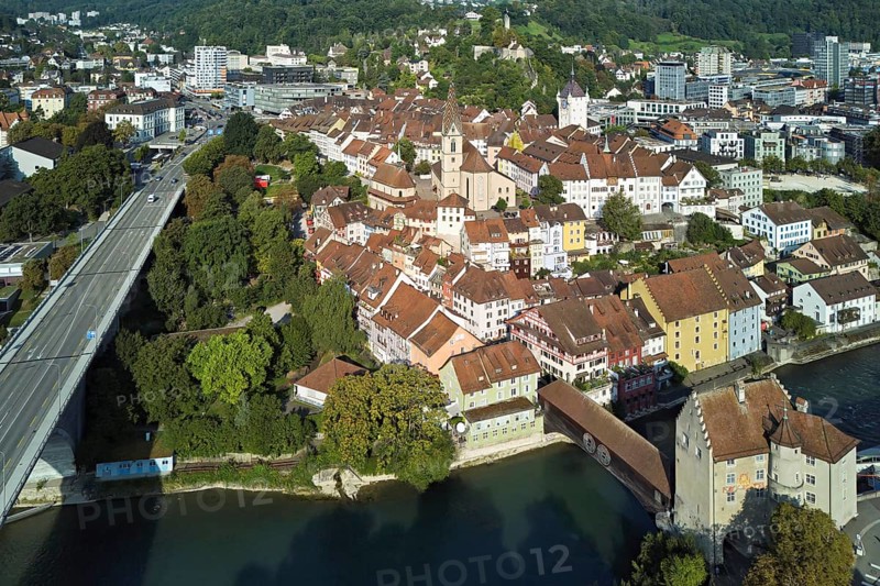 View of the old town with the parish church Maria Himmelfahrt, on the left the high bridge, behind the castle ruin Stein formerly an administrative centre of the Habsburgs, in front the river Limmat and the covered wooden bridge with the Landvogteischloss, Baden, Canton, Aargau, Switzerland