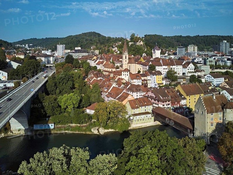 View of the old town with the parish church Maria Himmelfahrt, on the left the high bridge, behind the castle ruin Stein formerly an administrative centre of the Habsburgs, in front the river Limmat and the covered wooden bridge with the Landvogteischloss, Baden, Canton, Aargau, Switzerland