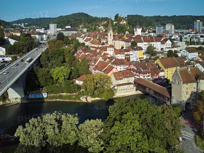 View of the old town with the parish church Maria Himmelfahrt, on the left the high bridge, behind the castle ruin Stein formerly an administrative centre of the Habsburgs, in front the river Limmat and the covered wooden bridge with the Landvogteischloss, Baden, Canton, Aargau, Switzerland