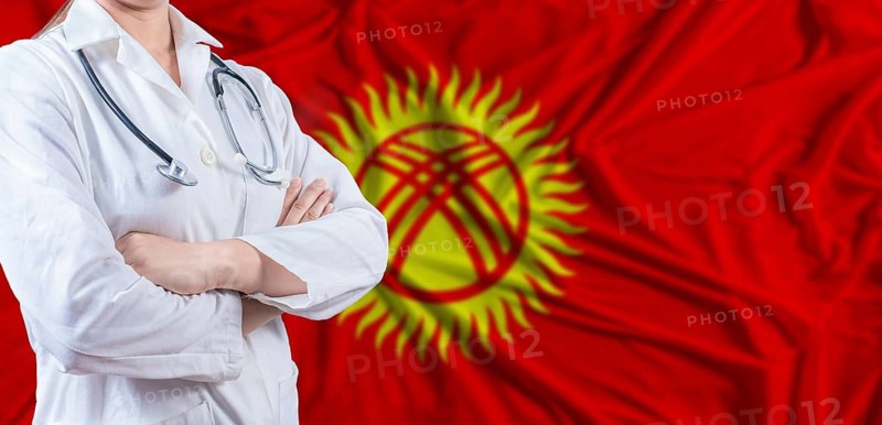 Doctor with crossed arms on Kyrgyzstan flag. Kyrgyzstan health and care concept. Female doctor on Kyrgyzstan flag