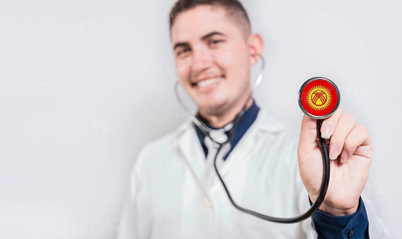Doctor showing stethoscope with Kyrgyzstan flag. Kyrgyzstan national healthcare concept