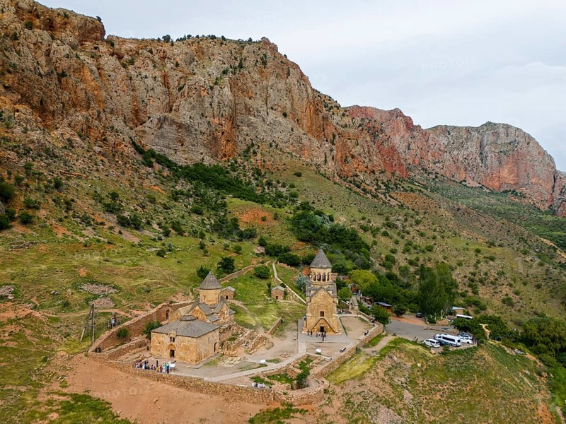 Church landscape in front of dramatic rock formations, surrounded by green nature, in a secluded mountain location, aerial view, Noravank Monastery, on the right mausoleum church Surb Astvatsatsin and on the left Baptist church Surb Karapet, Noravank, Vayots Dzor province, Vayots Dzor, Armenia, Caucasus