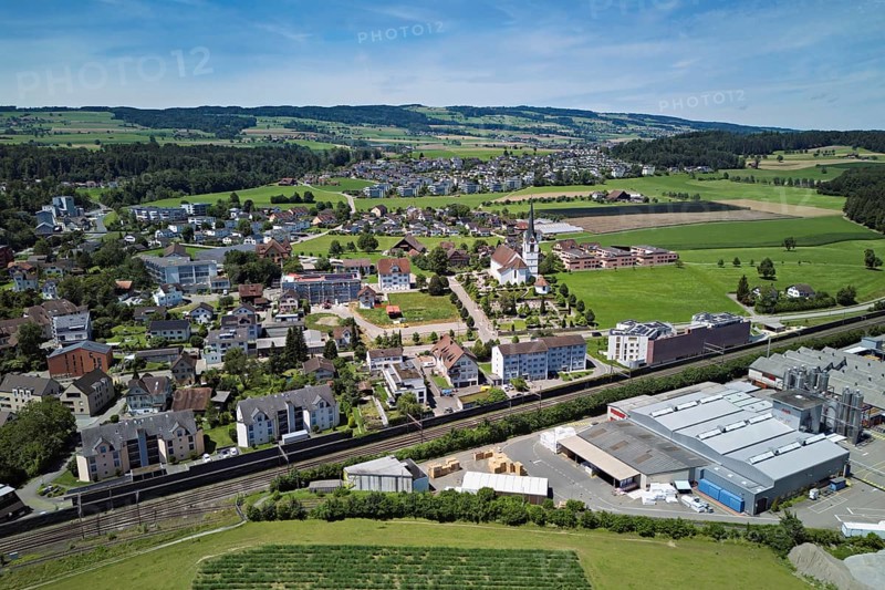 View of the village with the catholic parish church Mariä Geburt, on the right the industrial area, behind the Lindenberg, Sins, Freiamt, Canton, Aargau, Switzerland