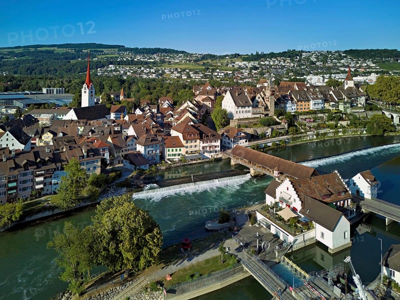 Old town with the Catholic Church of St Nicholas and the tower of the Muri- Amthof, in the foreground the weir and the museum Reusskraftwerk Bruggmühle on the river Reuss, Bremgarten, Freiamt, Canton, Aargau, Switzerland