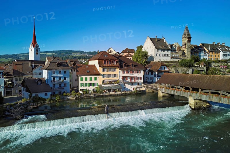 Old town with the Catholic Church of St Nicholas and the tower of the Muri- Amthof, in the foreground the weir, the old wooden bridge over the river Reuss, Bremgarten, Freiamt, Canton, Aargau, Switzerland